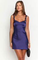 blonde model wears a navy blue satin mini dress with floral details