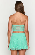 Rear view of a teal strapless lace corset top with a sheer ruched panel at the back and lace overlay