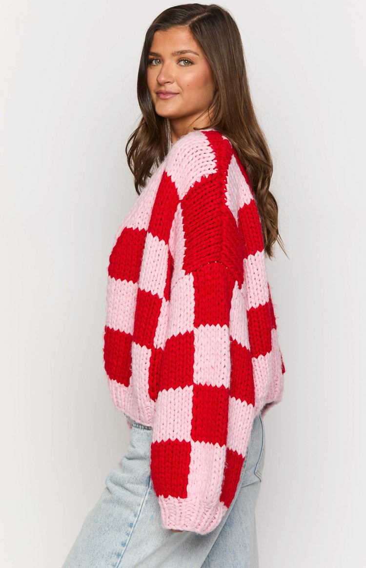 Side view of the chunky knit pink and red checkered cardigan with an oversized sleeve