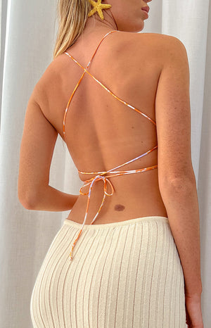 Rear view of the orange floral crop top with criss-cross spaghetti straps and a tie-back detail