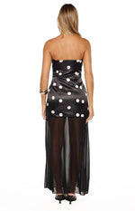 Rear view of a black strapless polka dot maxi dress with a satin mini dress under a sheer maxi skirt overlay