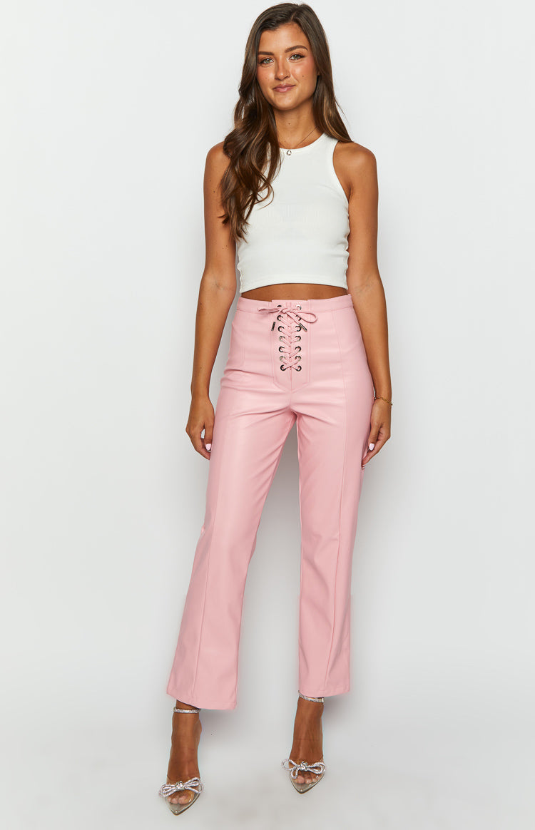 Front view of pink PU leather pants with a high-waisted lace-up detail and straight cropped legs