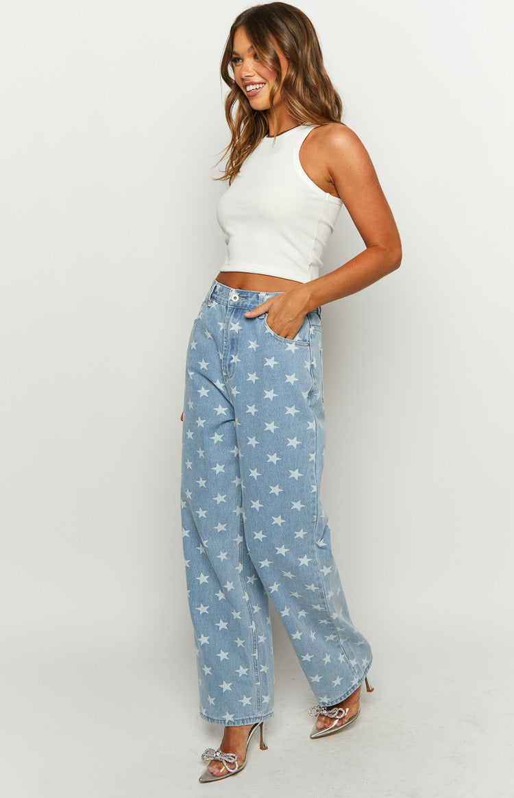 Side view of mid wash denim wide leg jeans with all-over white star print and high waist