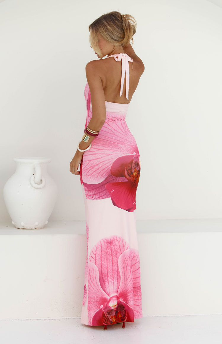 Rear view of a pink orchid print maxi dress showing the halter neck tie and open back