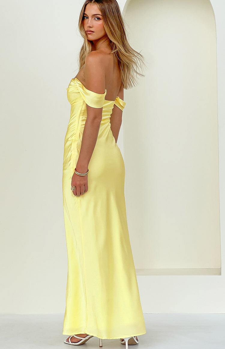 Side view of a light yellow off-shoulder maxi dress with a sweetheart neckline and ruched detail at the waist