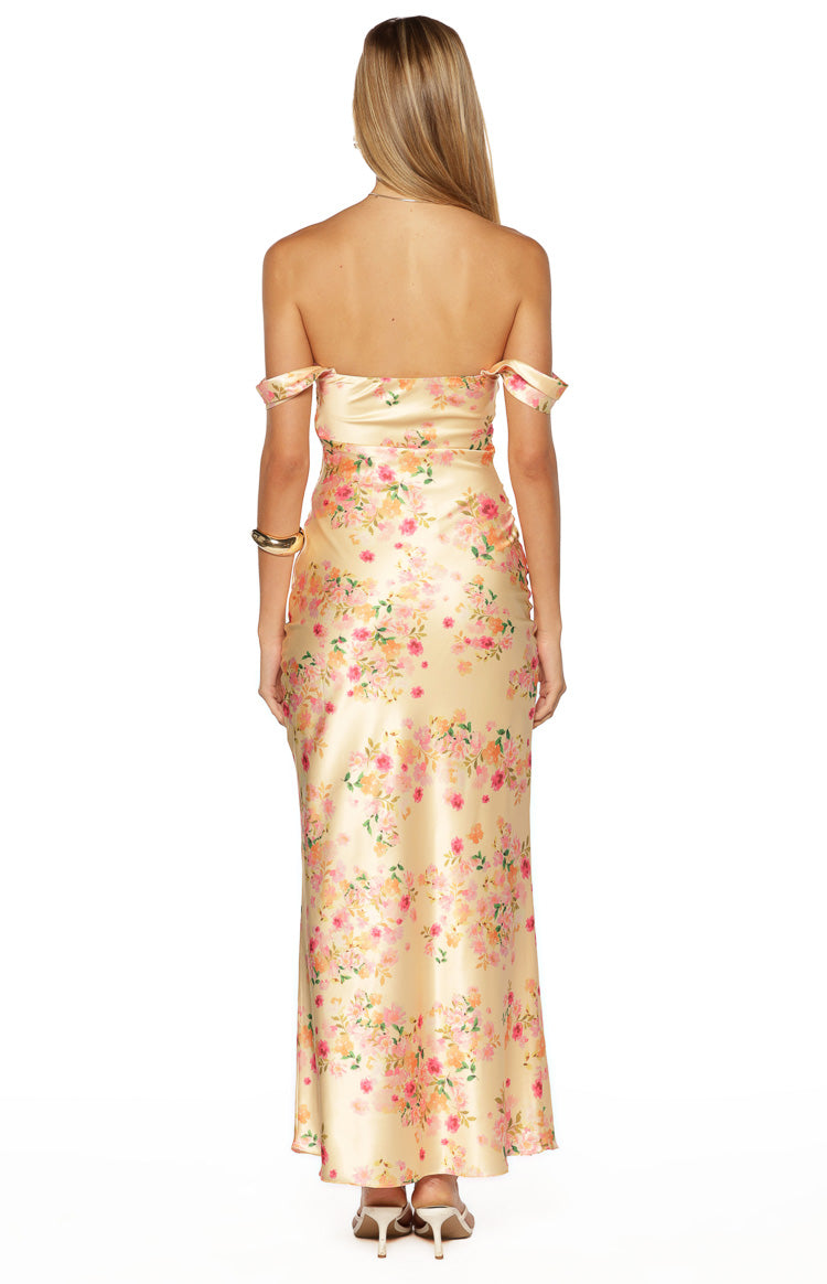 Rear view of a yellow satin off-shoulder maxi dress with a pink and orange floral print