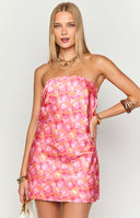 Girl wearing a vibrant orange floral print mini dress with pink and yellow blooms- a sleek strapless neckline and a smooth- figure-accentuating silhouette