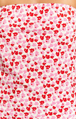 Close-up of the white fabric with a speckled pattern of small pink and red flowers
