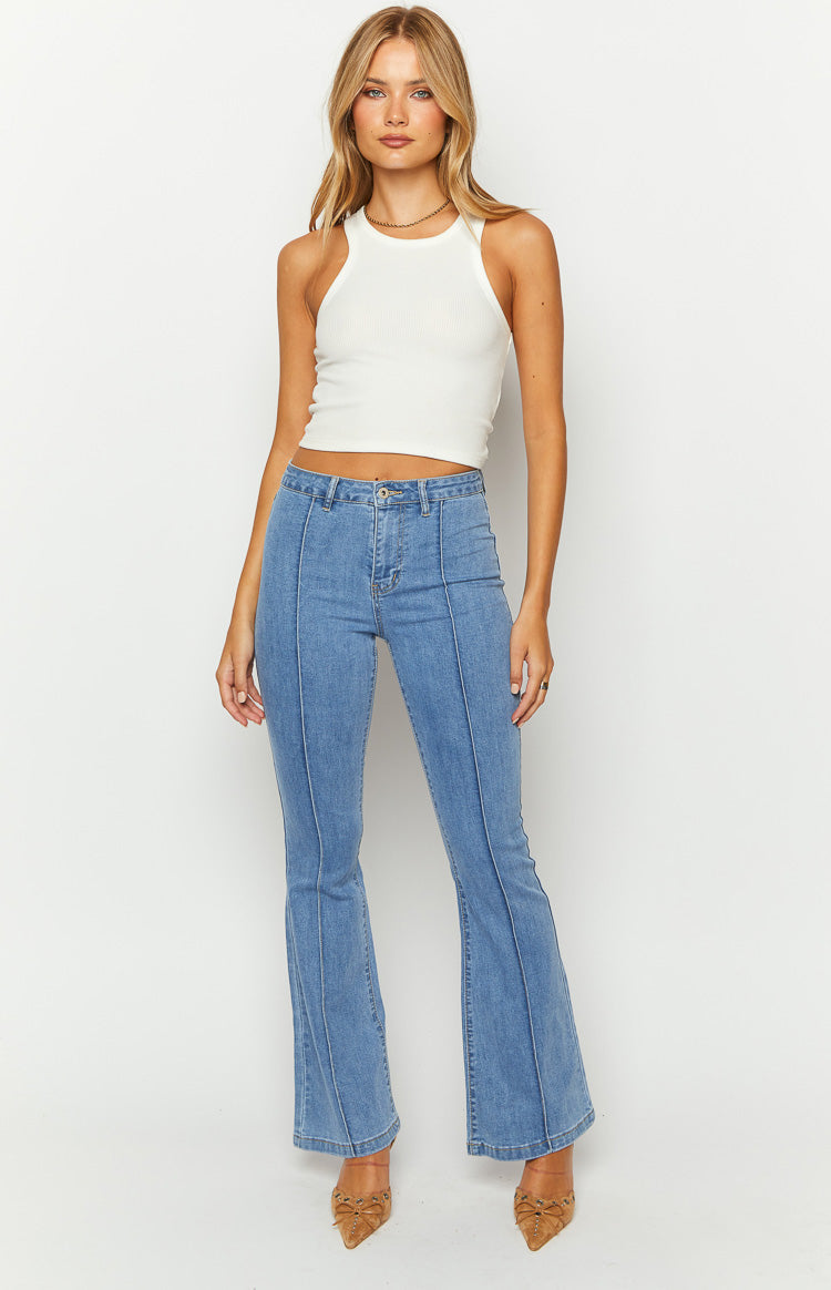 Mid wash blue flared denim jeans with a high waist and a prominent stitched seam down the front of each leg