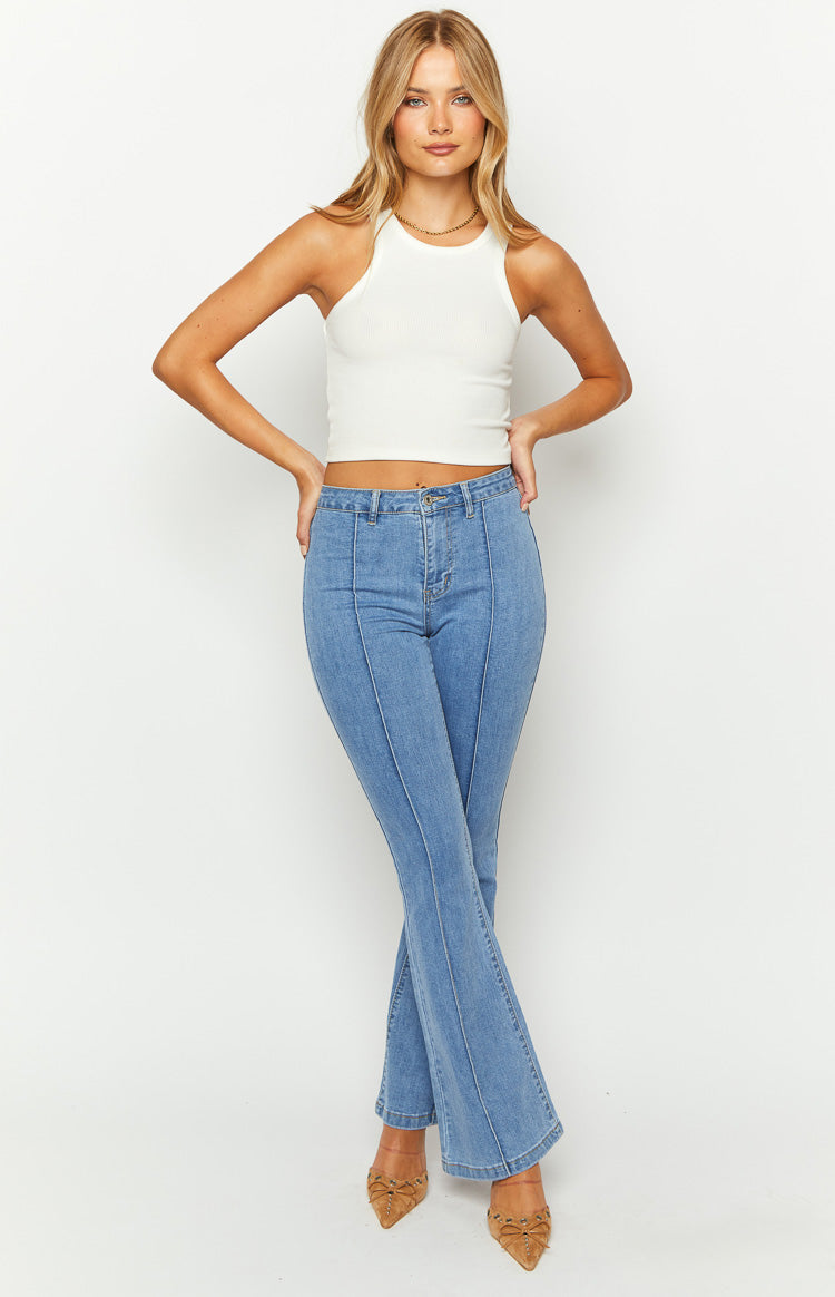Mid wash blue denim flared jeans with a prominent vertical seam down the front of each leg