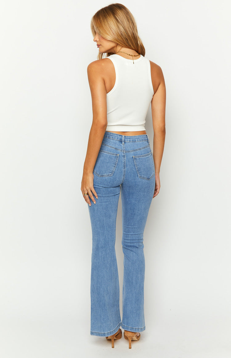 Front view of mid wash denim jeans highlighting the button closure, belt loops, and vertical seams