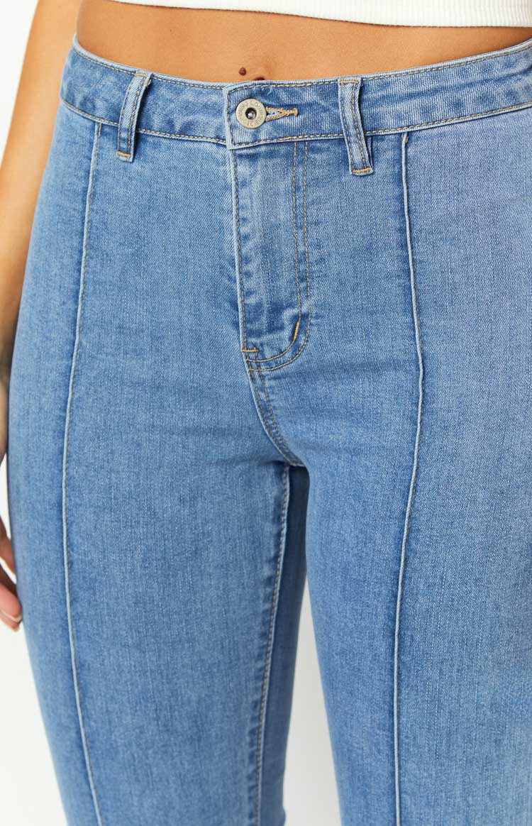 Full length view of mid wash flared denim jeans with prominent front seam details