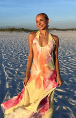 Yellow hibiscus floral halter maxi dress with a flowy skirt, highlighting the fabric's soft drape