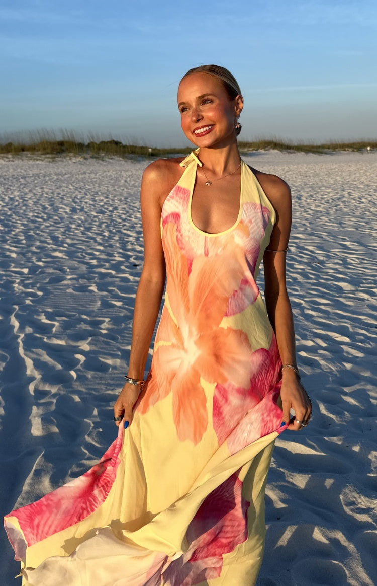 Yellow hibiscus floral halter maxi dress with a flowy skirt, highlighting the fabric's soft drape