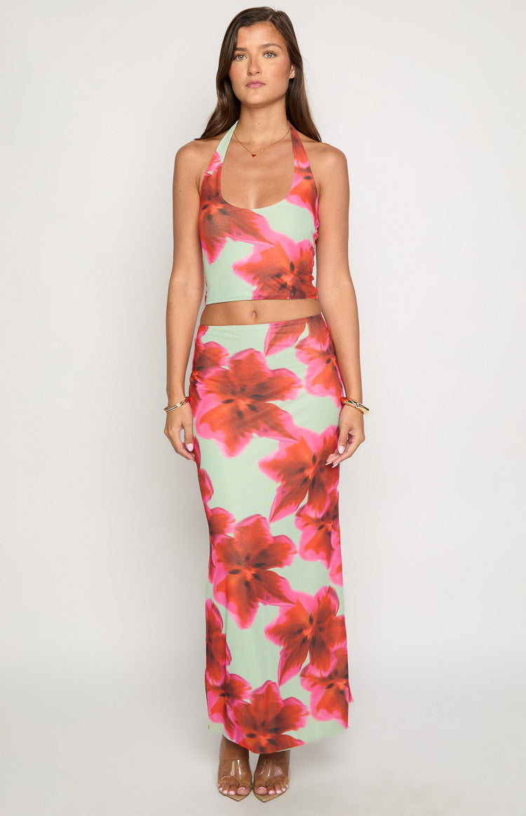 Front view of a light green maxi skirt with a vibrant red and pink floral print, featuring a fitted high waist and straight silhouette
