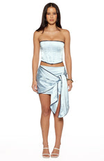 Light blue satin mini skirt with a wrap-around design and long tie detail on the side, trimmed with black lace