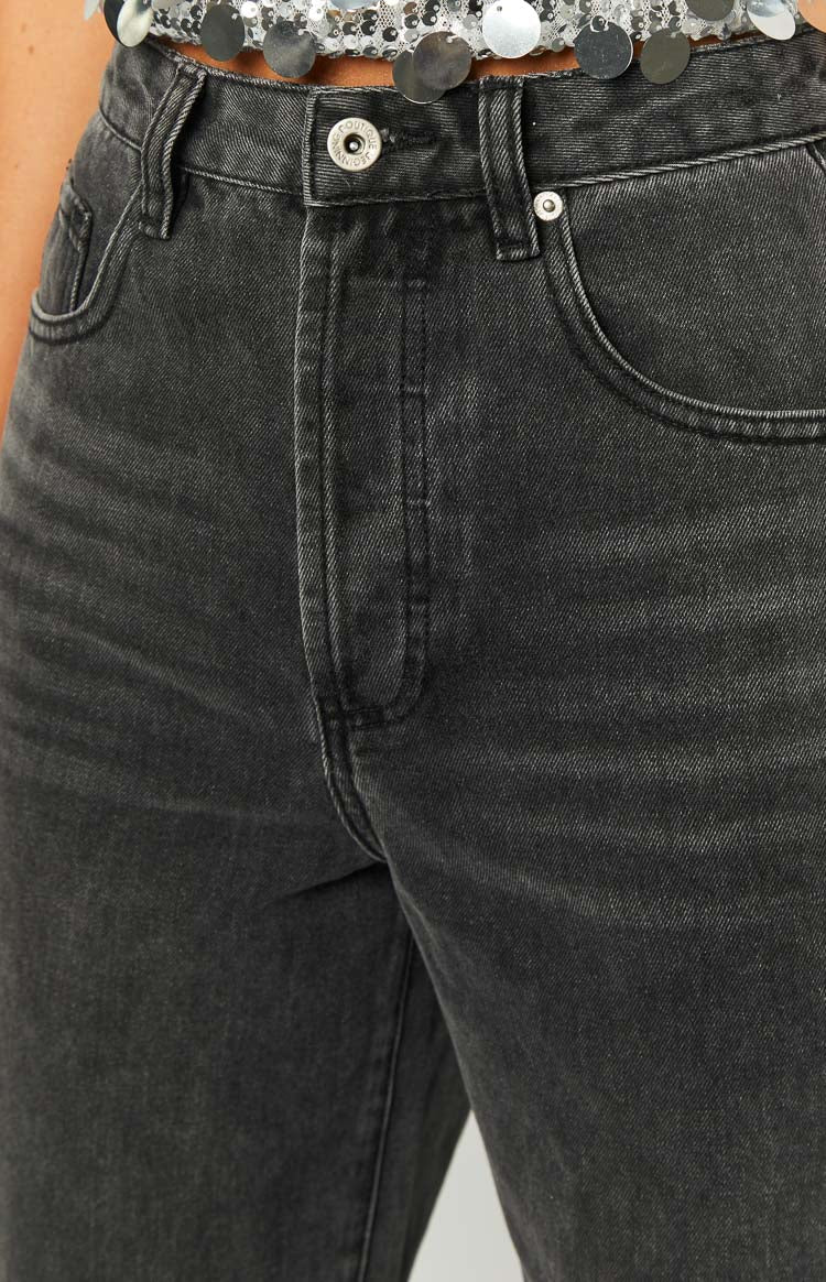 Close-up of the black denim jeans showing the button closure, front pockets, and fly detail