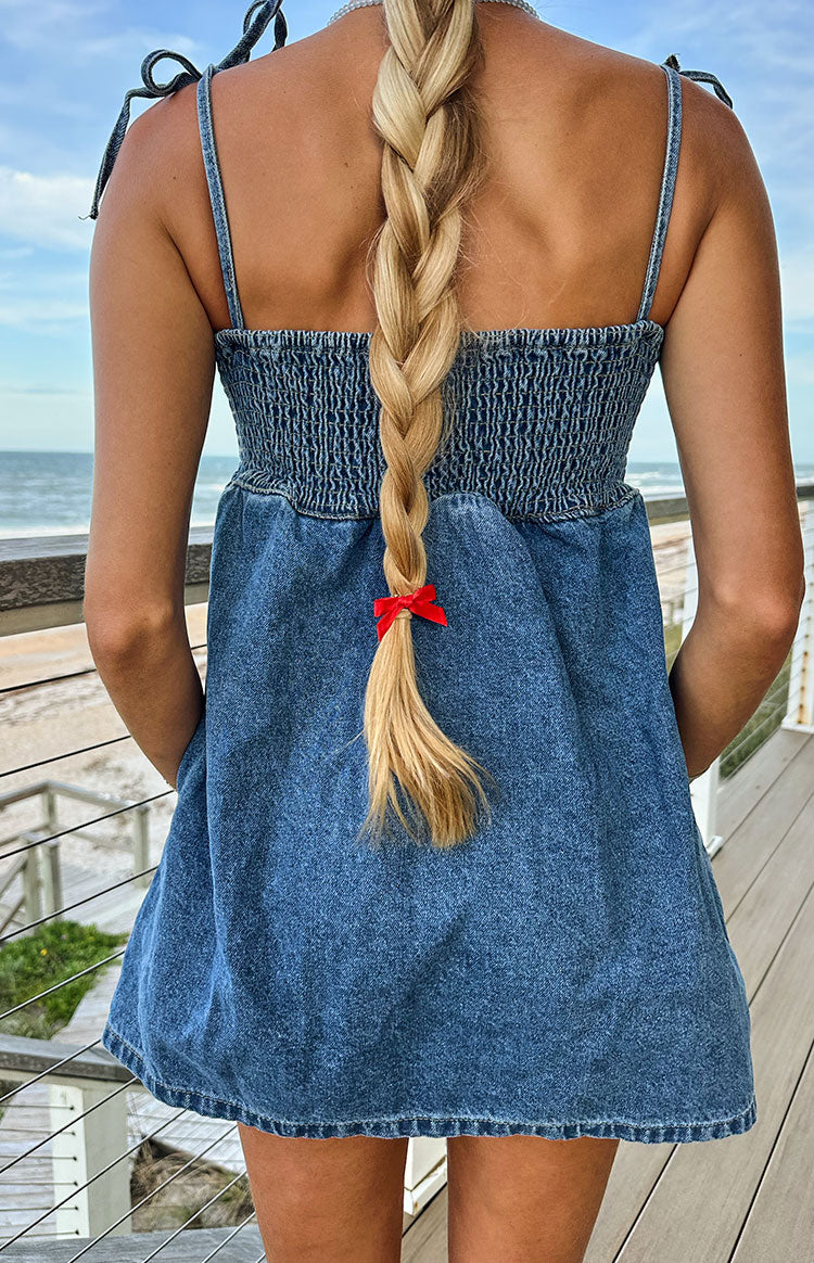 Rear view of a blue denim mini dress with a shirred bodice and tie straps