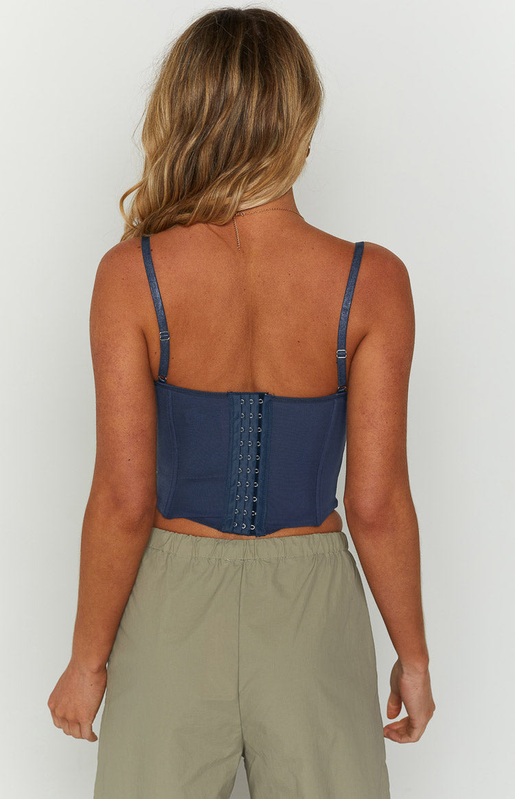 Rear view of a blue corset top featuring a full-length hook and eye closure and adjustable spaghetti straps