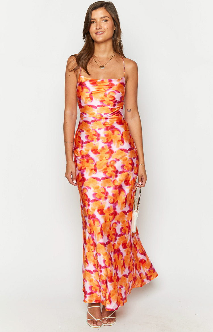 Front view of a pink orange and red abstract floral print midi dress with a cowl neckline