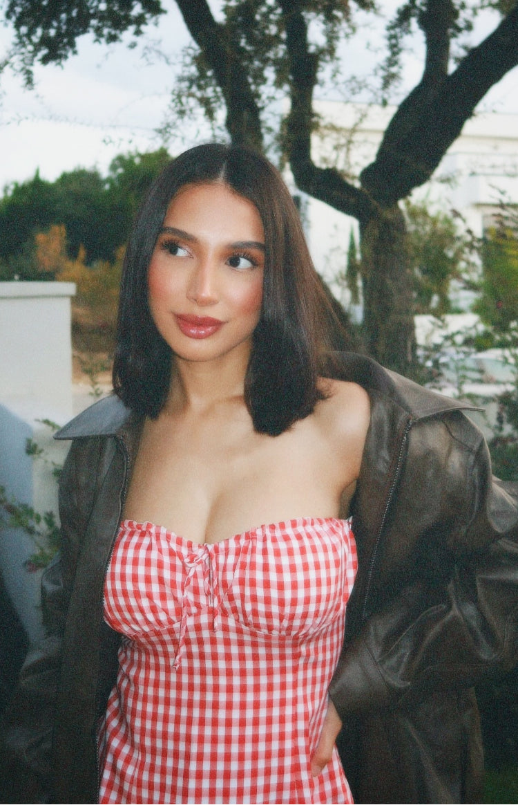 Close-up of the red gingham strapless mini dress showing the ruched bust with a tie detail