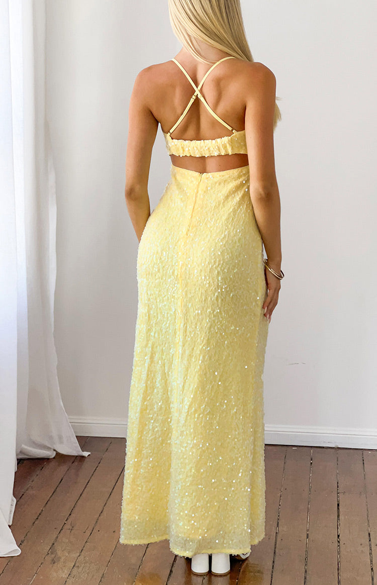 Rear view of a yellow sequin formal maxi dress with criss-cross back straps, ruched elastic band, and waist cut-out