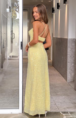Back view of a yellow sequin maxi dress with thin criss-cross straps and a cut-out waist