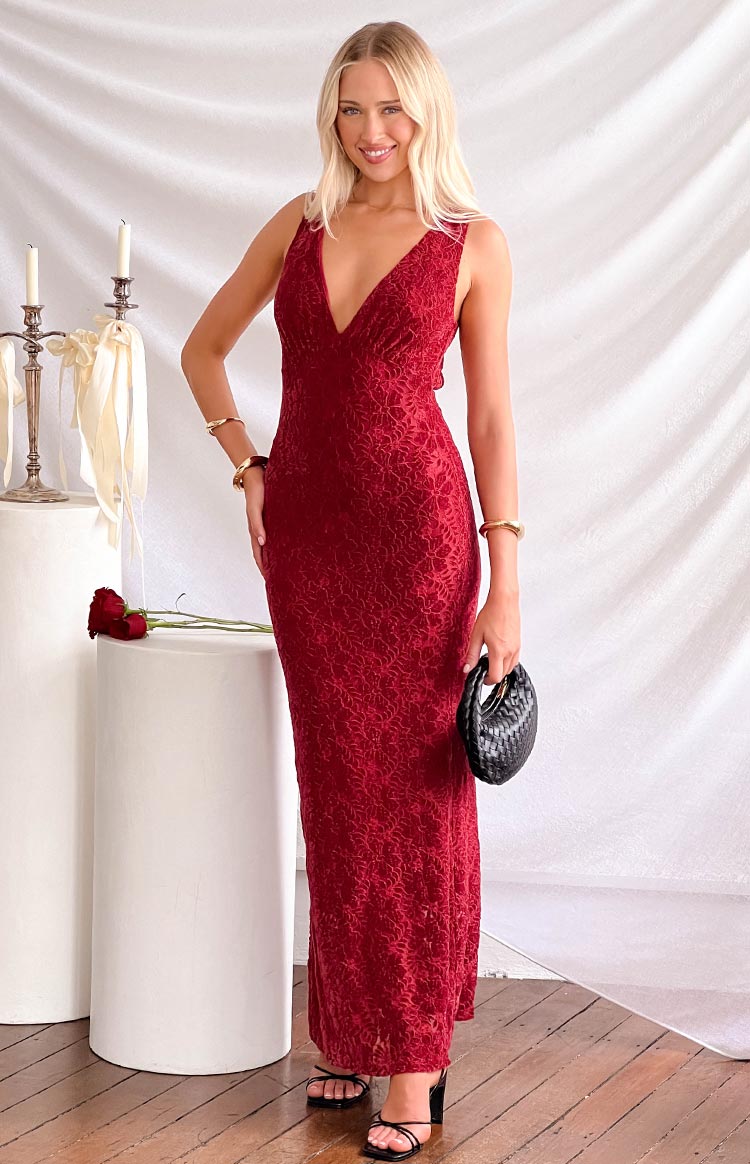 Front view of a red lace maxi dress with a deep V-neck, sleeveless design, and textured floral pattern