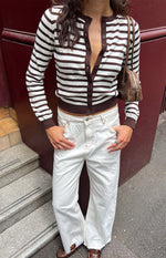 Relaxed fit white wide-leg denim jeans with visible contrast tan stitching and a raw frayed hem