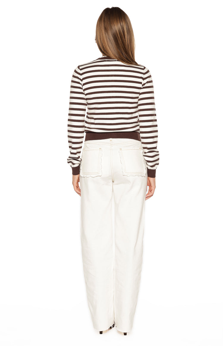 Rear view of white denim jeans showing scallop edge back pockets and contrast stitching
