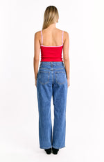 Rear view of the red ribbed knit top with thin adjustable pink spaghetti straps and pink trim