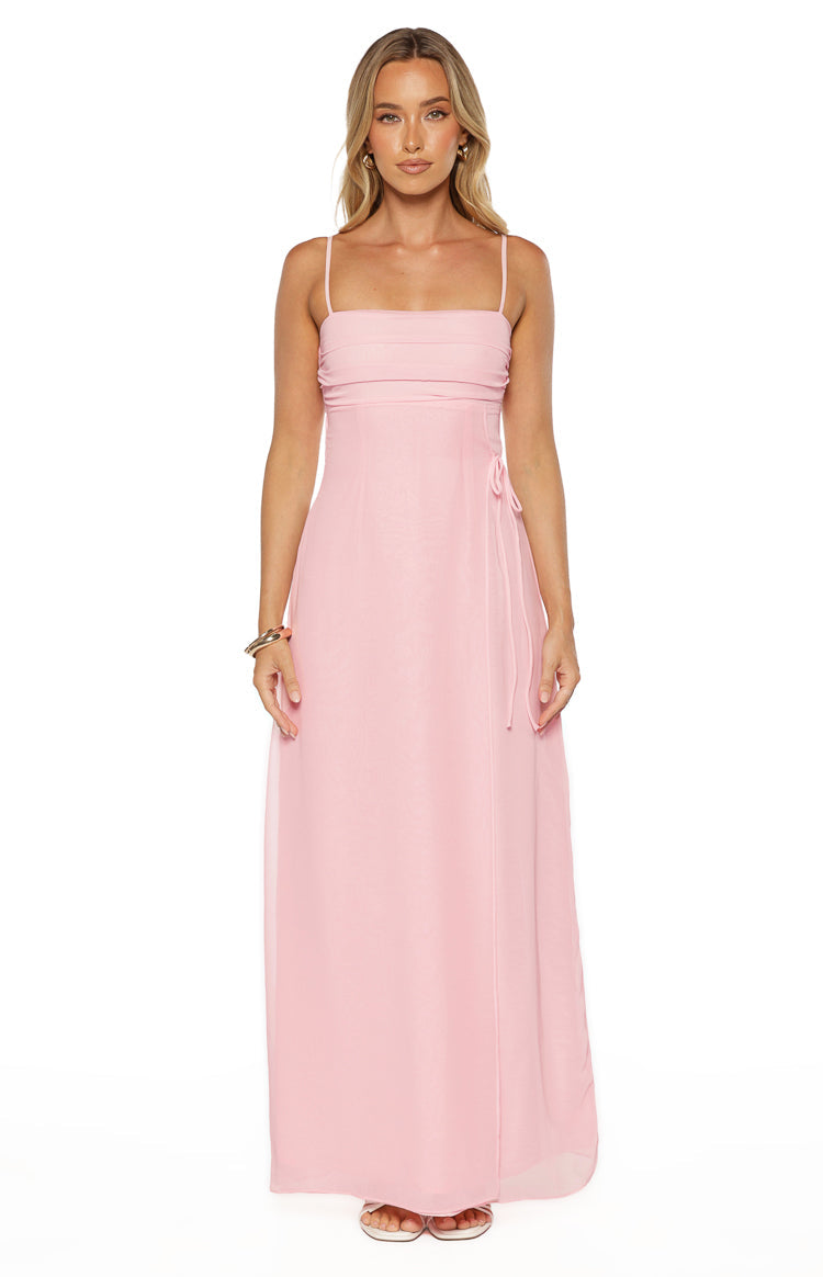 Pink sleeveless maxi dress with a ruched bodice, adjustable side tie, and sheer overlay fabric