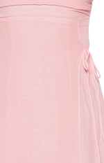Close-up of the sheer pink fabric and delicate side tie detail on the maxi dress