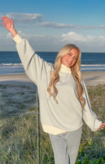 Blue and white stripe mock neck sweater featuring oversized balloon sleeves and a wide ribbed hem