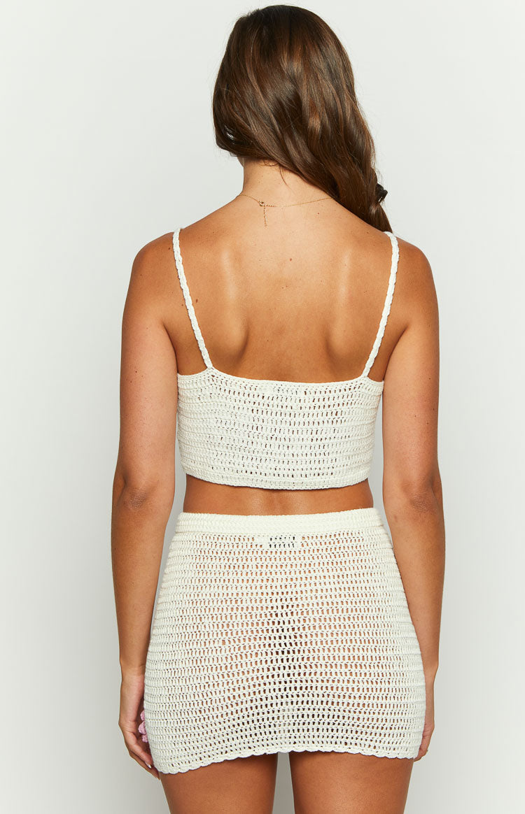 Rear view of a white crochet crop top with thin spaghetti straps and a straight back neckline