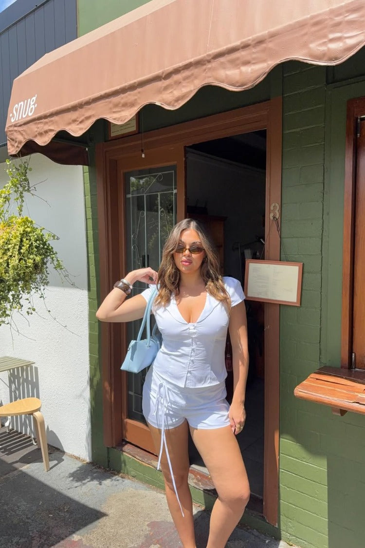 White relaxed fit shorts with long drawstring ties on the sides