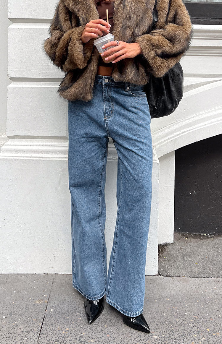 Full length view of mid wash wide leg jeans with a relaxed fit and visible front pockets
