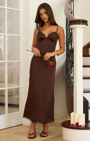 Model wearing a chocolate brown satin midi dress with black lace trim on the cups elegant for a Cocktail party
