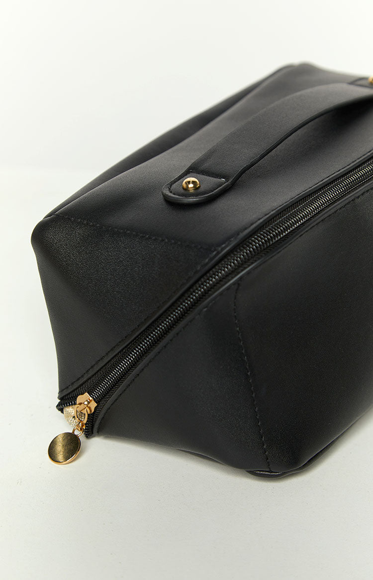 Open black cosmetic bag with light beige satin lining, featuring an internal zippered pocket and elasticated side compartments