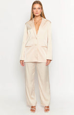 Cream satin blazer with a single button closure and notched lapels, styled with matching wide-leg pants