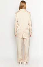Back view of a cream satin blazer with a collar, long sleeves, and a single vent at the hem
