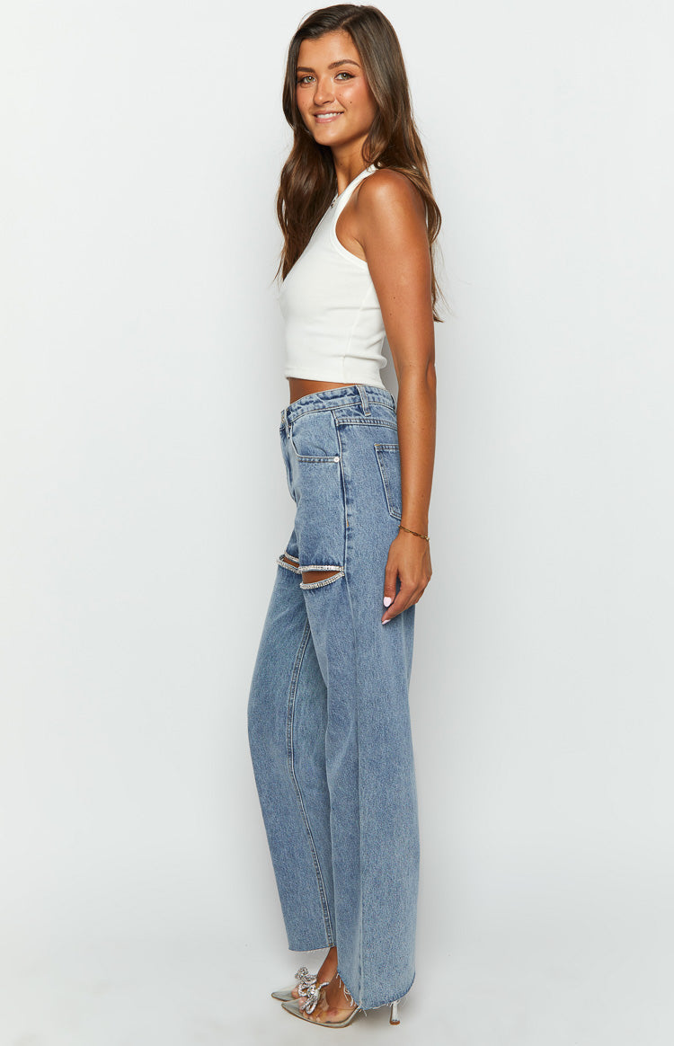 Side view of light blue wide leg denim jeans with diamante trim cutouts on the thighs