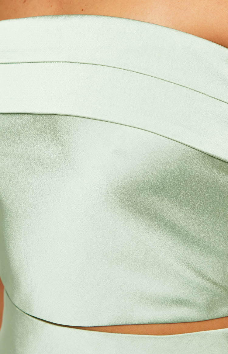 Rear view of a sage satin top with a draped cowl back and shirred elastic strap