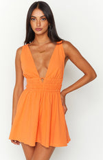 Orange crinkle mini dress with a deep V-neckline, shirred waist, and small cutout detail