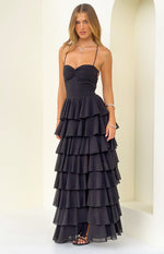 Front view of a black maxi dress with a ruched sweetheart neckline and full tiered ruffle skirt
