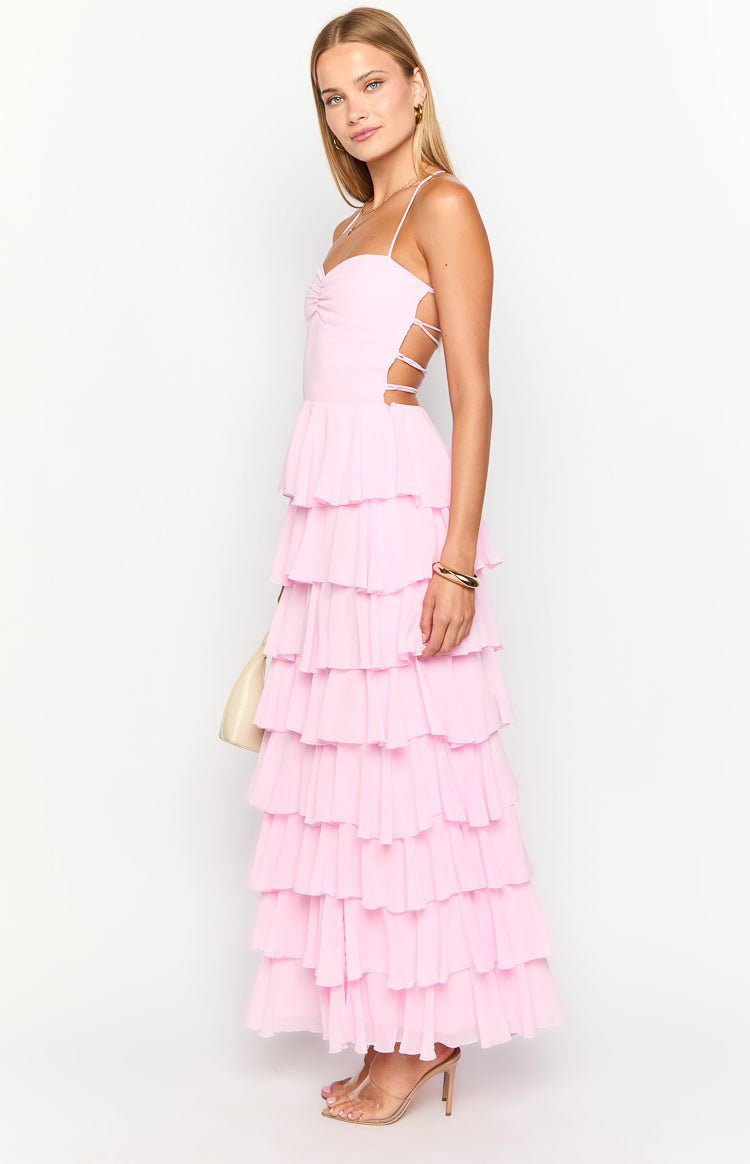Side view of a pink tiered ruffle maxi dress with ruched bust and lace-up side cutouts