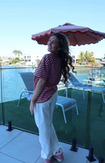 Side view of a pink and maroon horizontal striped oversized tee with short sleeves