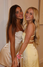 Close-up of the cream sequin bodice and satin skirt of a party mini dress with spaghetti straps