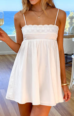 White mini dress with eyelet embroidered bodice, scalloped trim, and a gathered skirt