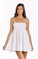 White babydoll mini dress with delicate eyelet embroidery along the square neckline and thin spaghetti straps